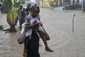 Residents wade through a flooded street in the aftermath of Hurricane Melissa in Petit-Goave, Haiti, Thursday, Oct. 30, 2025. (AP Photo/Odelyn Joseph)